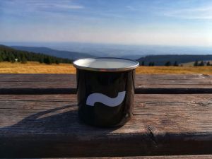 Na vršku světa - v popředí  plecháček s logem Jaboku, v pozadí hory